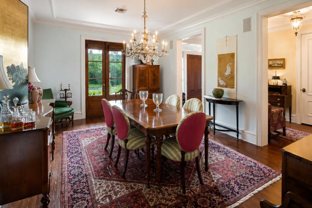 Urban Life Low Country formal dining room with crystal chandelier and French doors by Posada Custom Homes in Orlando, FL