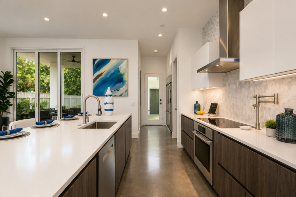 Urban Life modern kitchen with quartz island, hexagon tile backsplash, and sliding glass doors by Posada Custom Homes in Orlando, FL