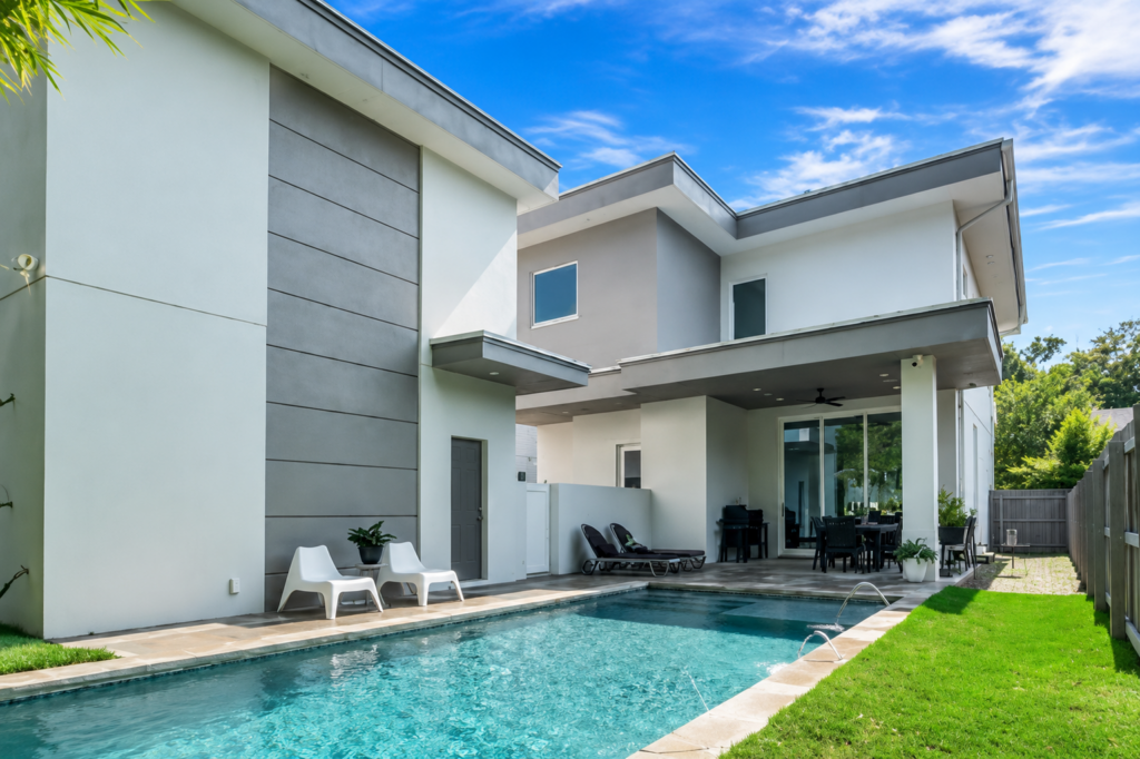 Urban Life modern rear exterior with covered patio, pool, and contemporary gray facade by Posada Custom Homes in Orlando, FL