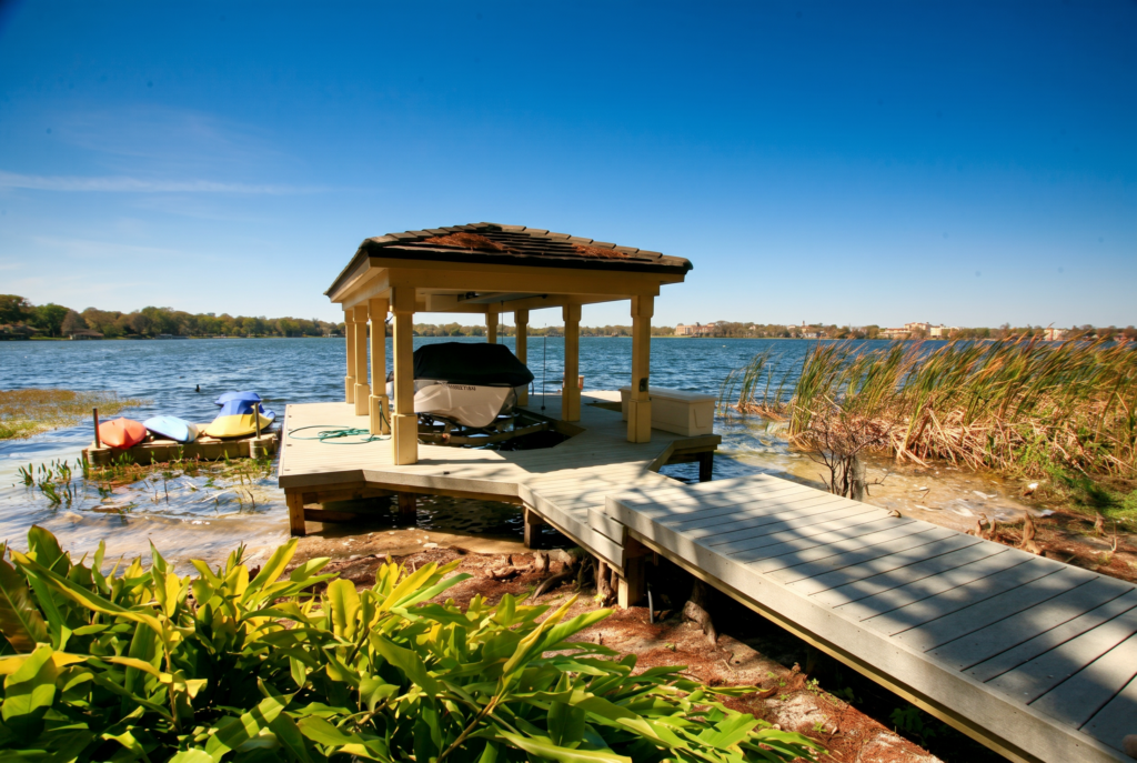 Private boat dock with a covered boathouse and wood walkway on a Central Florida lake
