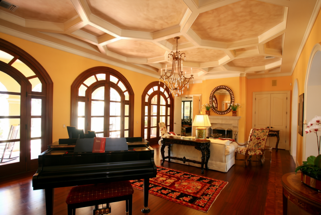 Living room with an octagonal coffered ceiling, arched mahogany French doors, and a fireplace