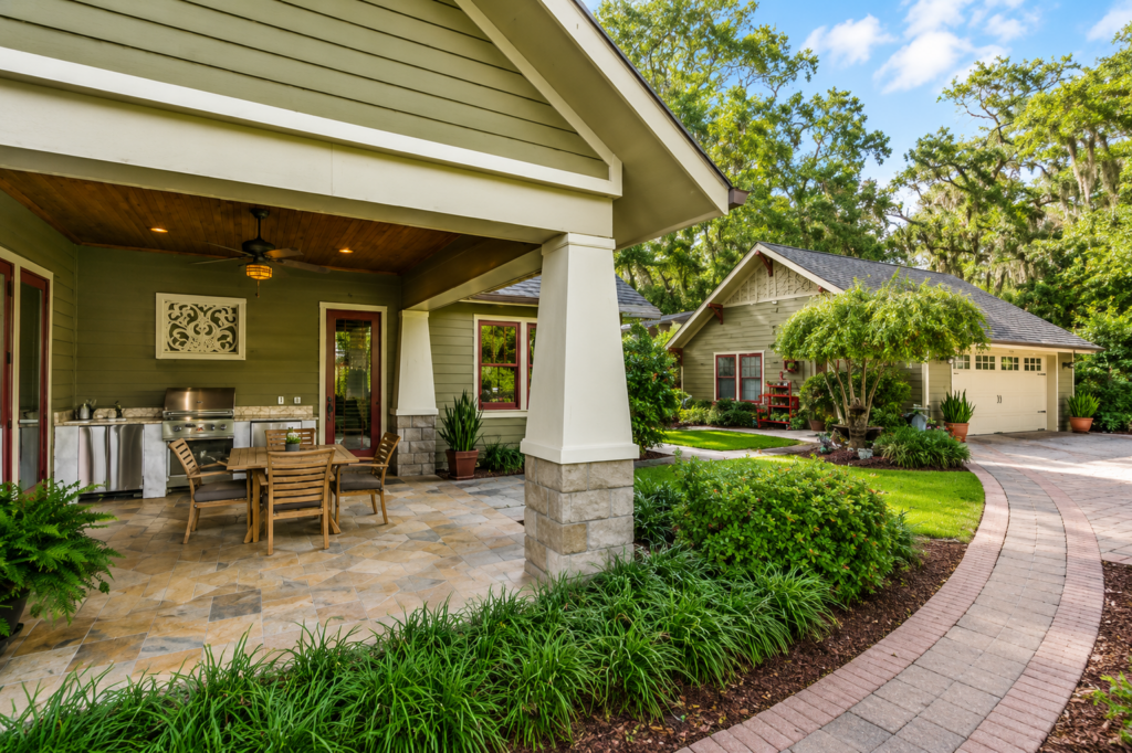 Covered outdoor kitchen with exposed rafters, a tapered column, and a flagstone patio