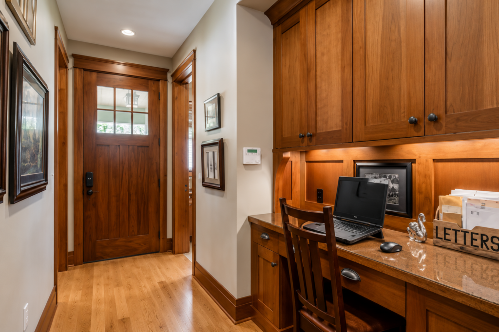 Entry with a Craftsman front door, wood wainscoting, and a built-in desk