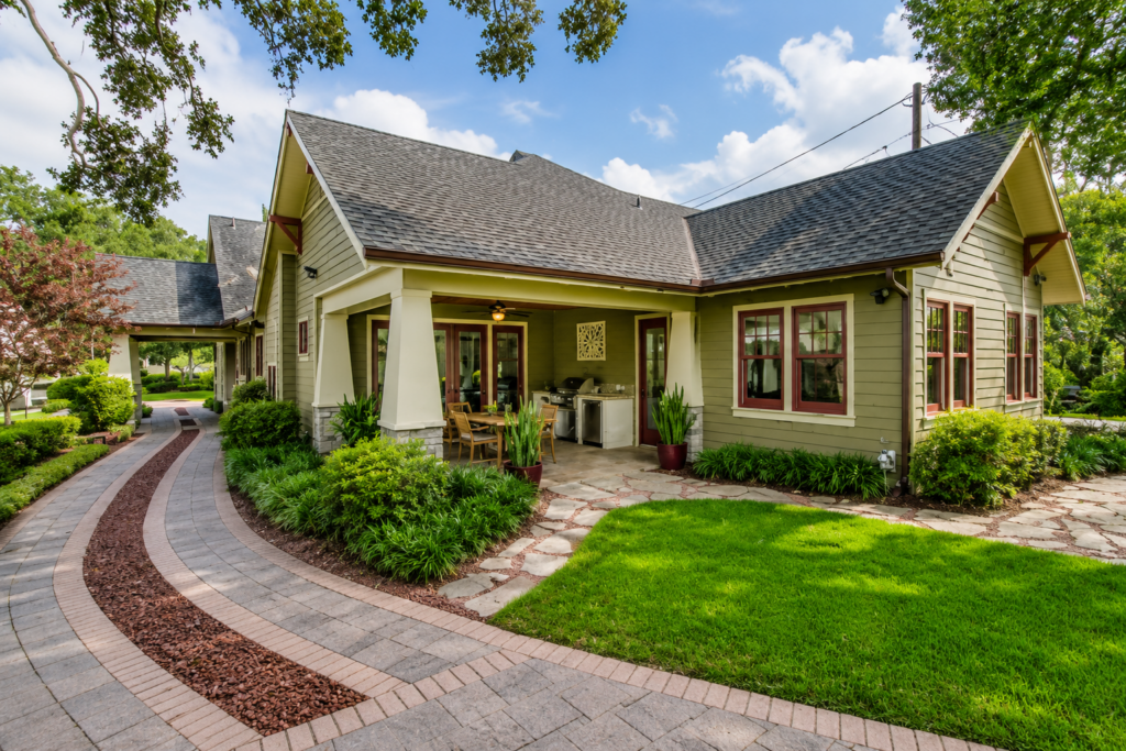 Rear elevation with a covered porch, brick paver walks, and flagstone patio