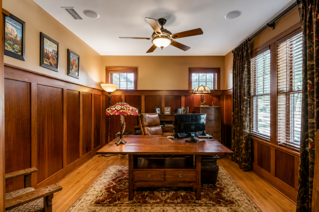 Study with full wood wainscoting, built-in cabinetry, and a Craftsman art glass lamp