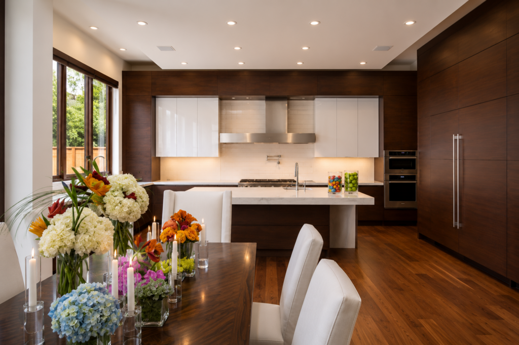 Kitchen with walnut cabinetry, high-gloss white uppers, a waterfall island, and wide plank floors