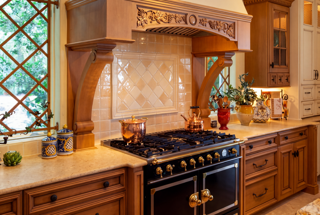 Kitchen range wall with a carved wood hood on corbels, a French range, and a diamond-set tile backsplash