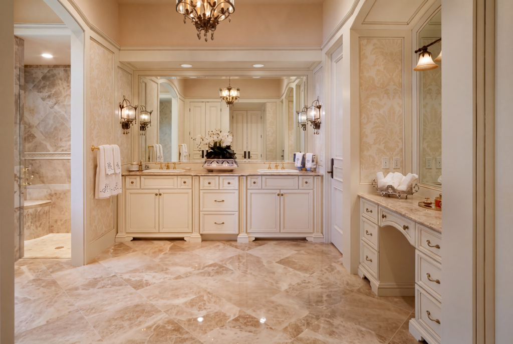 Primary bathroom with a stone floor, dual vanities, a makeup desk, and a walk-in shower