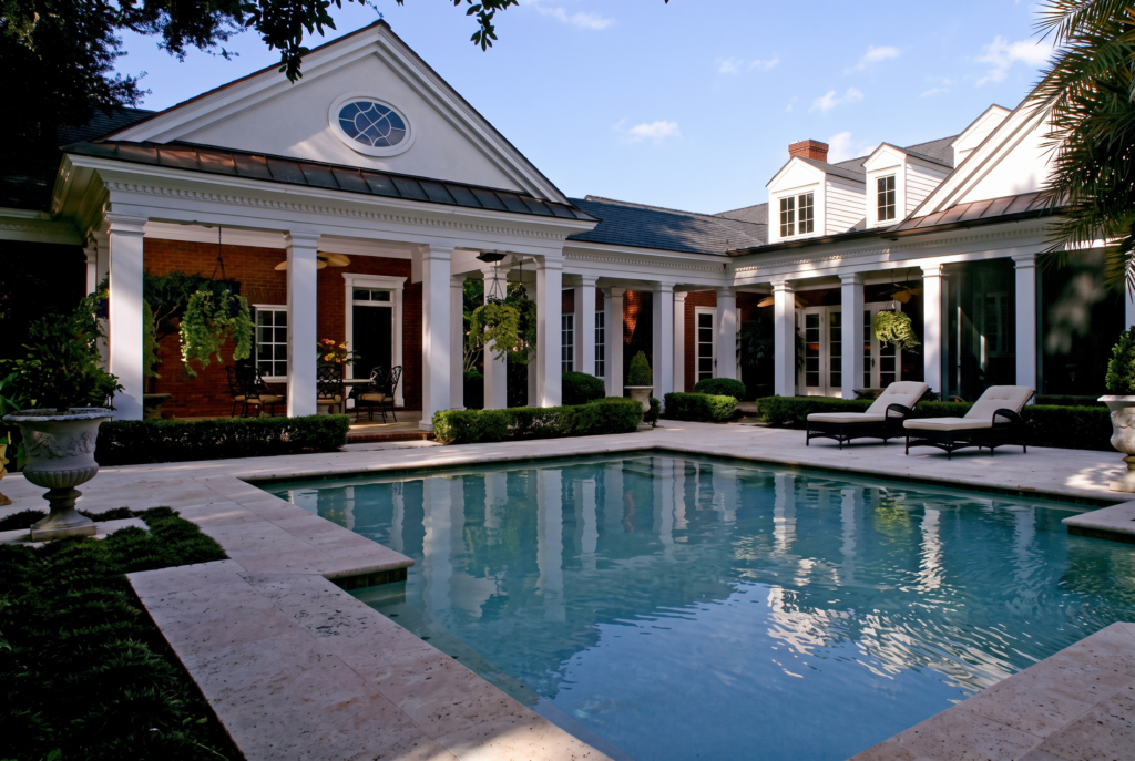 Rear courtyard with a lap pool framed by a colonnaded loggia and a pedimented pavilion