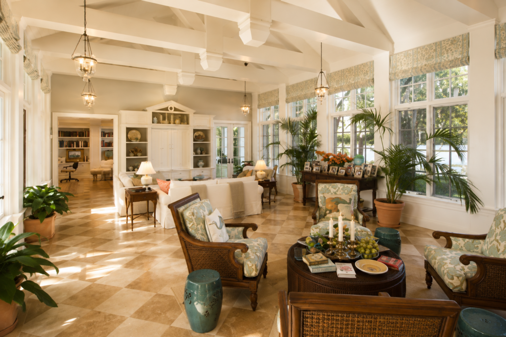 Great room under a vaulted ceiling with painted timber trusses, lantern pendants, and built-in bookcases