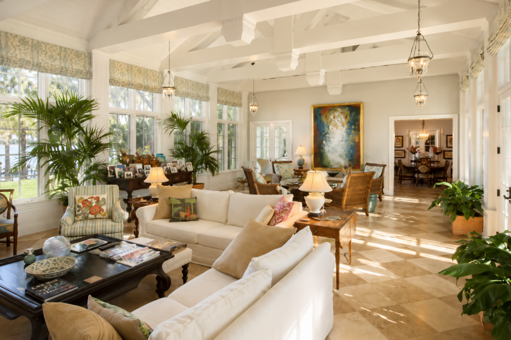 Great room looking toward the dining room, with tall windows, roman shades, and travertine floors throughout